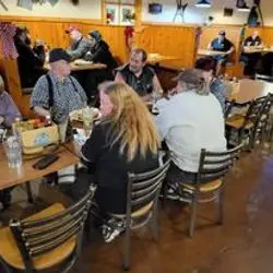 A group of people sitting at tables in a restaurant.