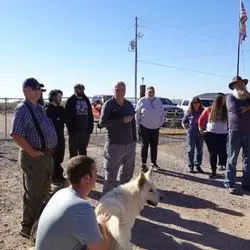 A group of people standing around with a dog.