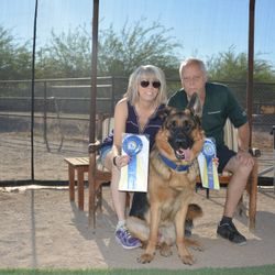 A man and woman sitting next to each other with their dog.