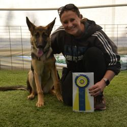 A woman and her dog are posing for the camera.