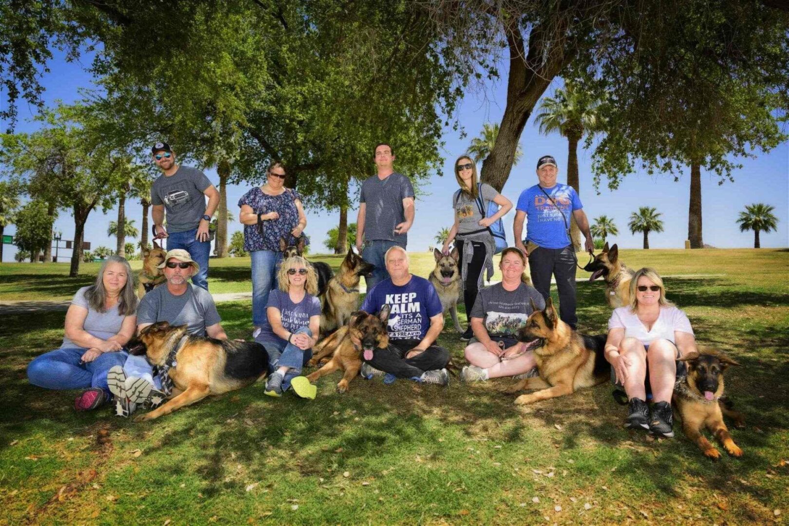 A group of people and their dogs posing for the camera.