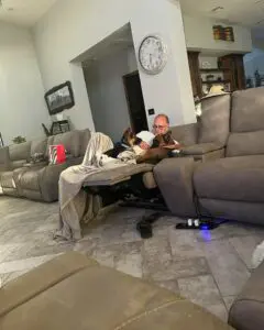 A man and his dog are sitting on the couch.