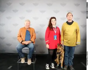 A group of people and a dog posing for a picture.